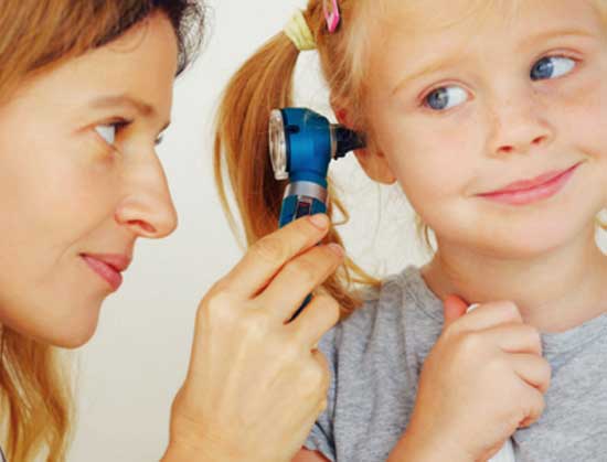 Doctor checking little girl's ear with otoscope